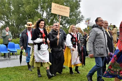 W niedzielę 29 sierpnia 2021 r. w Parku Papieskim w Rzeszowie odbyły się Dożynki Diecezjalne. Mimo deszczowej pogody do Parku Papieskiego przyjechało 57 delegacji z parafii diecezji rzeszowskiej z 65 wieńcami. Tegoroczną obsługę dożynek, w tym przygotowanie liturgii, zapewnili wierni i duszpasterze z dekanatu Rzeszów Wschód. Przed Mszą św. członkowie Stowarzyszenia Przyjaciół Ziemi Słocińskiej zaprezentowali program słowno-muzyczny. Podczas Mszy św. wystąpił chór z parafii św. Rocha w Rzeszowie pod dyrekcją Krzysztofa Husa oraz Gminna Orkiestra Dęta z Krasnego. Przed rozpoczęciem Mszy św. ks. Jerzy Uchman, diecezjalny duszpasterz rolników, przywitał przybyłych do Rzeszowa rolników, ogrodników, sadowników i pszczelarzy, wśród nich starostów dożynek: Marka Leśniewskiego i Teresę Kilar z parafii św. Rocha w Rzeszowie. Mszy św. przewodniczył bp Jan Wątroba. W koncelebrze uczestniczył bp Kazimierz Górny, ks. Wiesław Szurek oraz blisko dwudziestu księży. W długiej procesji z darami do ołtarza podeszły delegacje wszystkich obecnych parafii przynosząc chleby, wino, miód i owoce. Na zakończenie liturgii Biskup Rzeszowski pobłogosławił przyniesione płody ziemi. Po błogosławieństwie poszczególne delegacje, przedstawiane przez ks. Rafała Flaka, dyrektora Wydziału Duszpasterskiego Kurii Diecezjalnej w Rzeszowie, zaprezentowały swoje wieńce.  Fot. ks. Tomasz Nowak