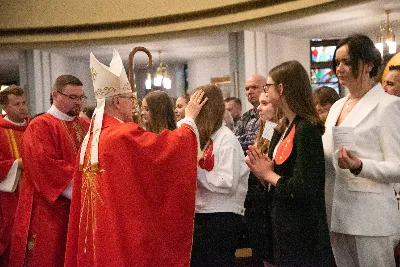 9 kwietnia w Katedrze 42 młodych osób z parafii katedralnej oraz 14 parafii Matki Bożej Częstochowskiej w Rzeszowie (Drabinianka) otrzymało sakrament bierzmowania, którego udzielił bp Jan Wątroba.
Przygotowania młodzieży trwały 2 lata, a odbywały się pod okiem ks. Krzysztofa, ks. Pawła, ks. Szczepana, s. Ewy oraz pani Agnieszki i obejmowały m.in. katechezy, spotkania formacyjne, a także przystąpienie do sakramentu pokuty. We wtorkowy wieczór kandydaci wraz ze swoimi świadkami, rodzicami, chrzestnymi czy też dziadkami zgromadzili się w Katedrze, by prosić o dary Ducha Świętego, umacniające w mężnym wyznawaniu wiary i postępowaniu według jej zasad.
Wszystkich zgromadzonych w świątyni przywitał ks. Krzysztof Gołąbek – proboszcz parafii katedralnej. Mszę Świętą koncelebrowali także ks. Tadeusz Pindara – proboszcz parafii Matki Bożej Częstochowskiej oraz kapłani posługujący w obydwu parafiach.
Następnie prośbę o udzielenie sakramentu bierzmowania zgromadzonym młodym oraz o modlitwę skierowali do Księdza Biskupa rodzice kandydatów.
W homilii bp Jan zachęcił młodych, aby w tym wyjątkowym dniu obrali Ducha Świętego za życiowego przewodnika towarzszącego im przy ważnych wyborach czy podchodzeniu do egzaminów – także tych życiowych. Wyjaśnił również znaczenie imienia Ducha Świętego – Paraklet – które tłumaczone z jęz. greckiego oznacza obrońcę, adwokata – nigdy prokuratora, nawet nie sędziego.
Będziecie moimi świadkami, gdy was umocni Duch Święty – mówi Pan Jezus. Niech nie będzie niedzieli i uroczystości bez udziału we Mszy Świętej – to jest moment dawania świadectwa. Właśnie przez zaangażowane, pełne uczestnictwo w najpiękniejszej modlitwie, jaką ma Kościół, czyli w Mszy Świętej, zdacie egzamin ze swojej dojrzałości chrześcijańskiej.
Na koniec celebrans odwołał się do obchodzonej poprzedniego dnia Uroczystości Zwiastowania Pańskiego i postawy Maryi wobec planu Bożego w Jej życiu oraz drogi, przez którą prowadził Ją Duch Święty. Podkreślił, że właśnie Maryja uczy, jak być uczennicą Ducha Świętego.
Po homilii miało miejsce odnowienie przyrzeczeń chrzcielnych. Następnie odbyła się najważniejsza część uroczystości – modlitwa Księdza Biskupa oraz namaszczenie krzyżmem każdego kandydata.
Sakrament bierzmowania jest koniecznym dopełnieniem sakramentu chrztu i wiąże się również z obraniem konkretnego patrona, którego życie i przymioty są wzorem dla młodego człowieka otrzymującego Ducha Świętego. Kandydat do bierzmowania ma więc okazję wybrać sobie świętego czy błogosławionego, którego droga do świętości najbardziej go zachwyciła. Może być to patron, którego imię nosi już od chrztu; może też wybrać sobie drugiego patrona. 
W związku z tym podczas namaszczenia krzyżmem biskup zwraca się do bierzmowanego nowo wybranym imieniem.
Po liturgii sakramentu bierzmowania miała miejsce modlitwa powszechna i liturgia eucharystyczna. Na koniec młodzi złożyli podziękowania Księdzu Biskupowi, Księżom Proboszczom oraz wszystkim, którzy poprzez swój wkład, posługę i zaangażowanie przyczynili się do przygotowania oraz przeżycia tej wyjątkowej uroczystości. Pamiątką było wspólne zdjęcie po zakończonej Mszy Świętej.
Posługę muzyczną w czasie uroczystości pełniła Katedralna Schola Liturgiczna pod dyrekcją ks. Juliana Wybrańca.

fot. Leszek Drzał
