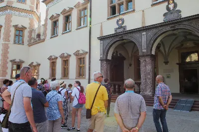 W ostatnią sobotę sierpnia katedralni parafianie pod opieką księdza proboszcza Krzysztofa Gołąbka pielgrzymowali do klasztoru na Świętym Krzyżu oraz Kielc.
Pierwszym punktem był spacer na platformę widokowo-obserwacyjną, gdzie mogliśmy podziwiać jedne z największych gołoborzy w Polsce. Gołoborza łysogórskie tworzą interesujące pola kamieni pośród lasów Puszczy Jodłowej. Nasyceni malowniczymi widokami udaliśmy się do Klasztoru Oblatów, gdzie z przewodnikiem zwiedziliśmy kryptę księcia Jeremiego Wiśniowieckiego, poznaliśmy historię powstawania Klasztoru oraz jego burzliwe dzieje. Zwiedziliśmy muzeum misyjne Ojców Oblatów i dotarliśmy do kaplicy, gdzie znajdują się relikwie drzewa Krzyża Świętego. W skupieniu i refleksji uczestniczyliśmy w modlitwie, błogosławieństwie i ucałowaniu relikwiarza.
Najważniejszym punktem na naszym pielgrzymim szlaku była Msza Święta sprawowana przez księdza proboszcza Krzysztofa Gołąbka w intencjach wszystkich uczestników pielgrzymki. Była ona dla nas szczególnym przeżyciem, ponieważ była odprawiana w Bazylice Mniejszej pw. Trójcy Świętej, sąsiadującej z kaplicą, w której znajduje się cząstka Ziemi Świętej – relikwie Świętego Krzyża. Po Mszy Świętej przyszedł czas na indywidualne zwiedzanie – wykorzystaliśmy go, aby wejść na platformę widokową wieży, skąd rozpościerają się wspaniałe i zachwycające widoki.
Następnie pojechaliśmy do Kielc, gdzie przy słonecznej pogodzie spacerowaliśmy po Rezerwacie Kadzielnia, podziwiając dawny kamieniołom, Skałkę Geologów, Pomnik Dekalogu oraz amfiteatr kielecki.
Z uwagi na wspaniały wystrój i wyjątkowe zabytki Bazyliki Katedralnej Wniebowzięcia Najświętszej Maryi Panny, ta świątynia na długo pozostanie w naszej pamięci. Podziwialiśmy również znajdujący się obok Bazyliki były Pałac Biskupów Krakowskich (obecnie znajduje się tam Muzeum Narodowe) oraz znajdujący się za nim ogród włoski.
Wycieczkę zakończyliśmy spacerem po rynku kieleckim, gdzie mogliśmy zobaczyć wyjątkowe mieszczańskie kamienice sprzed 150 lat.
Czas pielgrzymki był dla wszystkich pielgrzymów dobrze i owocnie spędzonym dniem. Nie zabrakło w nim modlitwy i refleksji, a także zachwytu nad pięknem przyrody i historycznymi zabytkami. Zachęcamy wszystkich do udziału w kolejnych pielgrzymkach.
Agnieszka i Arkadiusz Sowa
fot. Andrzej Kotowicz 