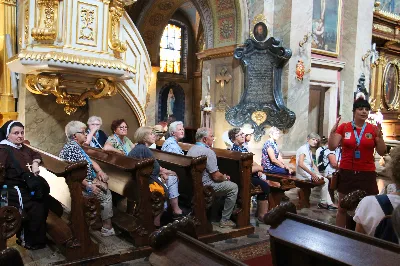 W ostatnią sobotę sierpnia katedralni parafianie pod opieką księdza proboszcza Krzysztofa Gołąbka pielgrzymowali do klasztoru na Świętym Krzyżu oraz Kielc.
Pierwszym punktem był spacer na platformę widokowo-obserwacyjną, gdzie mogliśmy podziwiać jedne z największych gołoborzy w Polsce. Gołoborza łysogórskie tworzą interesujące pola kamieni pośród lasów Puszczy Jodłowej. Nasyceni malowniczymi widokami udaliśmy się do Klasztoru Oblatów, gdzie z przewodnikiem zwiedziliśmy kryptę księcia Jeremiego Wiśniowieckiego, poznaliśmy historię powstawania Klasztoru oraz jego burzliwe dzieje. Zwiedziliśmy muzeum misyjne Ojców Oblatów i dotarliśmy do kaplicy, gdzie znajdują się relikwie drzewa Krzyża Świętego. W skupieniu i refleksji uczestniczyliśmy w modlitwie, błogosławieństwie i ucałowaniu relikwiarza.
Najważniejszym punktem na naszym pielgrzymim szlaku była Msza Święta sprawowana przez księdza proboszcza Krzysztofa Gołąbka w intencjach wszystkich uczestników pielgrzymki. Była ona dla nas szczególnym przeżyciem, ponieważ była odprawiana w Bazylice Mniejszej pw. Trójcy Świętej, sąsiadującej z kaplicą, w której znajduje się cząstka Ziemi Świętej – relikwie Świętego Krzyża. Po Mszy Świętej przyszedł czas na indywidualne zwiedzanie – wykorzystaliśmy go, aby wejść na platformę widokową wieży, skąd rozpościerają się wspaniałe i zachwycające widoki.
Następnie pojechaliśmy do Kielc, gdzie przy słonecznej pogodzie spacerowaliśmy po Rezerwacie Kadzielnia, podziwiając dawny kamieniołom, Skałkę Geologów, Pomnik Dekalogu oraz amfiteatr kielecki.
Z uwagi na wspaniały wystrój i wyjątkowe zabytki Bazyliki Katedralnej Wniebowzięcia Najświętszej Maryi Panny, ta świątynia na długo pozostanie w naszej pamięci. Podziwialiśmy również znajdujący się obok Bazyliki były Pałac Biskupów Krakowskich (obecnie znajduje się tam Muzeum Narodowe) oraz znajdujący się za nim ogród włoski.
Wycieczkę zakończyliśmy spacerem po rynku kieleckim, gdzie mogliśmy zobaczyć wyjątkowe mieszczańskie kamienice sprzed 150 lat.
Czas pielgrzymki był dla wszystkich pielgrzymów dobrze i owocnie spędzonym dniem. Nie zabrakło w nim modlitwy i refleksji, a także zachwytu nad pięknem przyrody i historycznymi zabytkami. Zachęcamy wszystkich do udziału w kolejnych pielgrzymkach.
Agnieszka i Arkadiusz Sowa
fot. Andrzej Kotowicz 